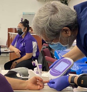 Health Worker Checking Blood Sugar